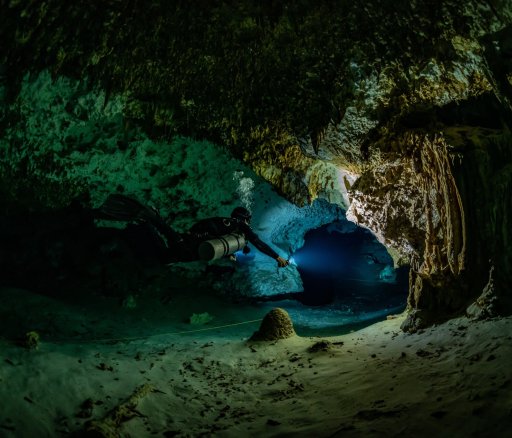 cave diver instructor leading a group of divers in a mexican cenote underwater