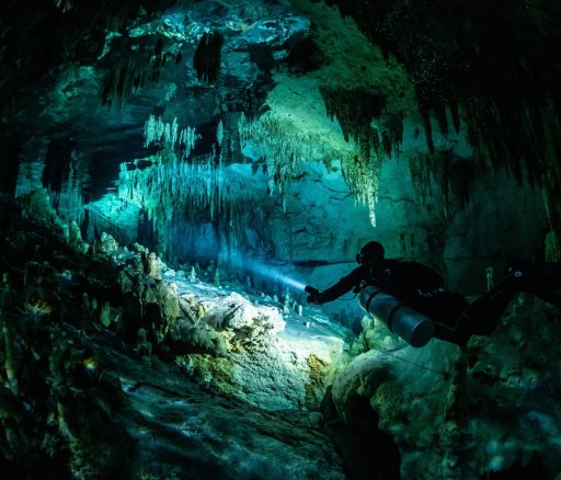 cave diver instructor leading a group of divers in a mexican cenote underwater